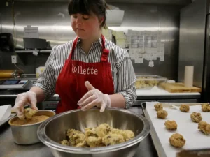 Photo of woman with Down syndrome making cookies at her cookie-making business.