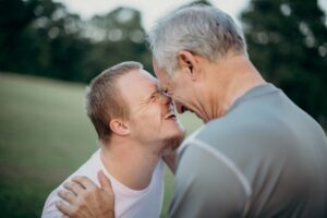 Color photo of older teen or young adult eye to eye (in a positive way) with an older male. 