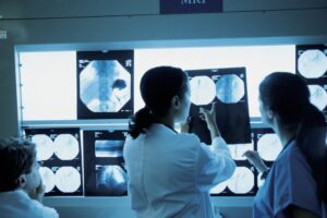 Tinted blue photo of radiologists looking at x-rays
